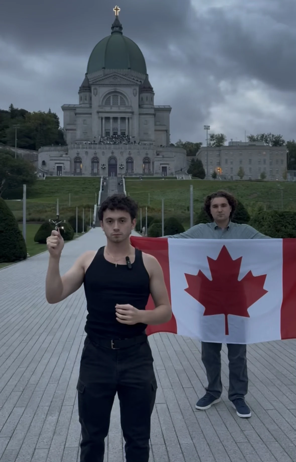 Justice standing with a Canadian flag outside a church