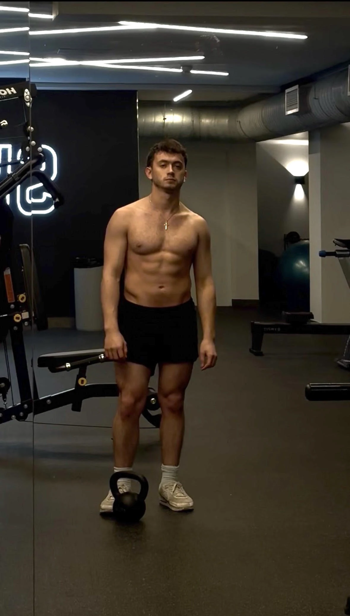 Justice wearing a cross necklace and holding a weight in the gym